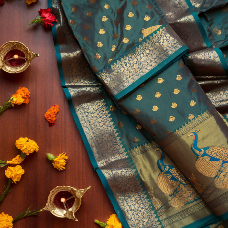 Close-up of a traditional Paithani saree with gold zari and peacock motifs.