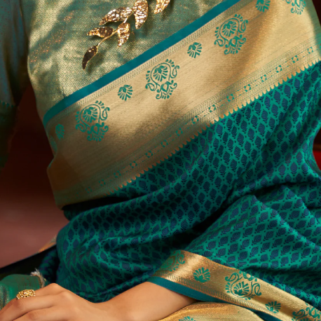Woman in a green saree from Dress & Dazzle, glowing with Hariyali Teej elegance and intricate embroidered border design.